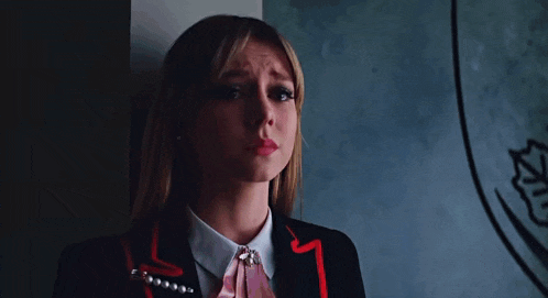 a woman in a suit and tie is crying in front of a mirror .