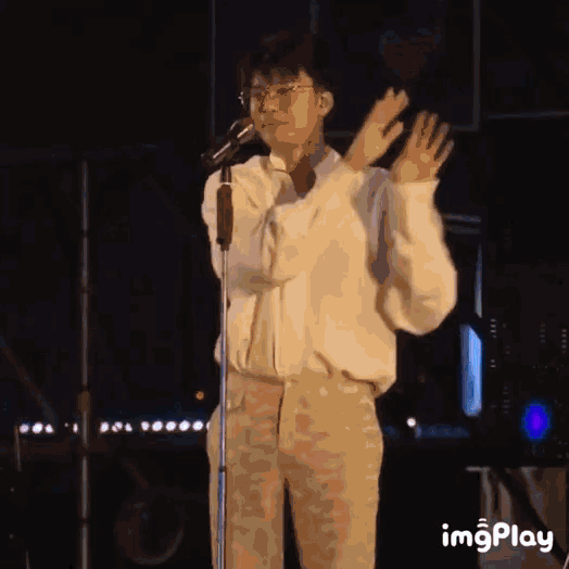 a man standing in front of a microphone with the word imgplay on the bottom