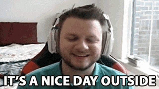 a man wearing headphones is smiling while sitting in a chair .