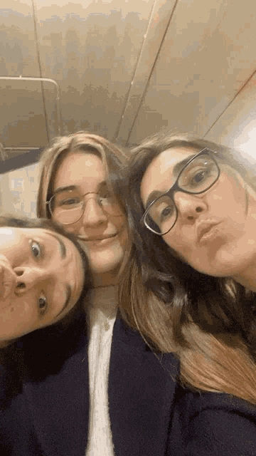 three women wearing glasses are posing for a selfie