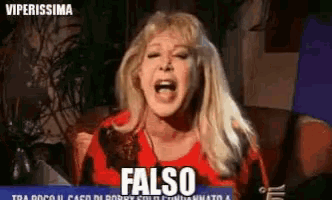 a woman in a red shirt is screaming and says " falso " on the screen