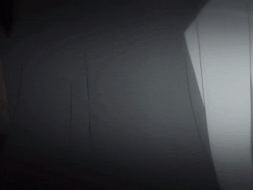 a dark room with a light coming out of the door
