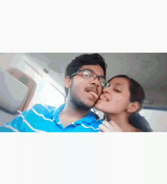 a man and a woman are kissing in a car and the woman is sticking her tongue out