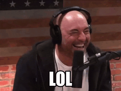 a bald man wearing headphones is laughing in front of a microphone with the word lol written on it