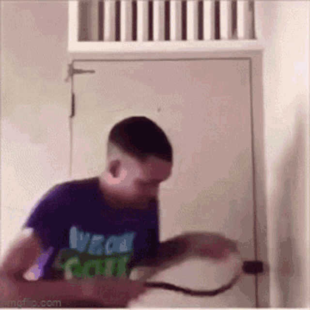 a man is holding a snake in front of a door .