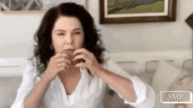 a woman is sitting on a couch in a living room making a face .