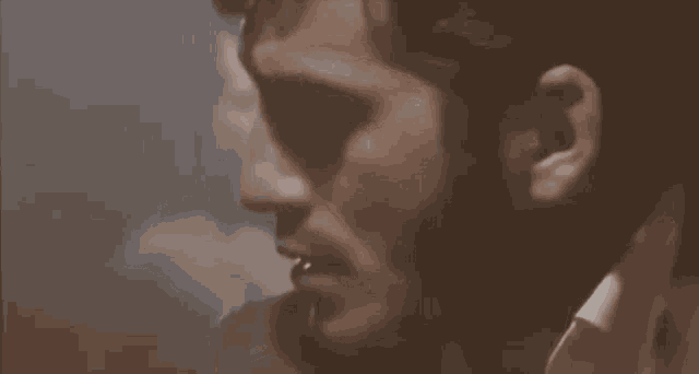 a close up of a man 's face with a beard in a dark room .