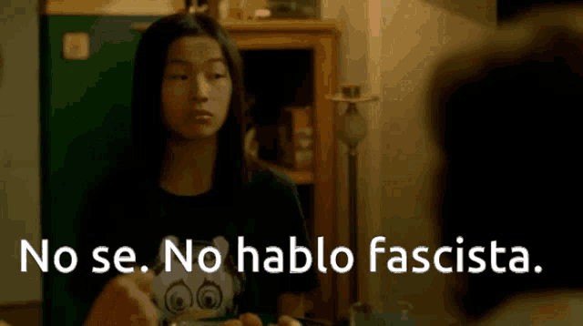 a woman sitting at a table with the words no se no hablo fascista written on the screen