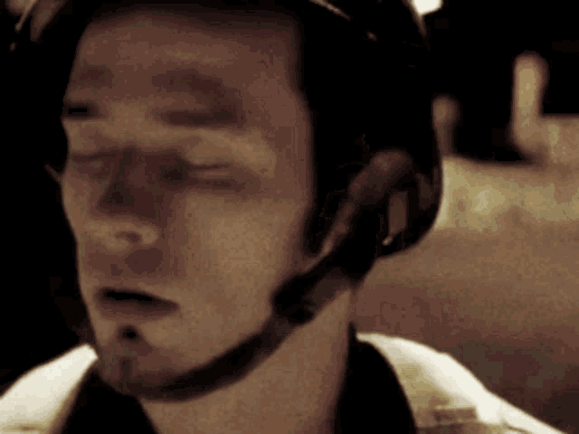 a man wearing a helmet with a headset on his neck