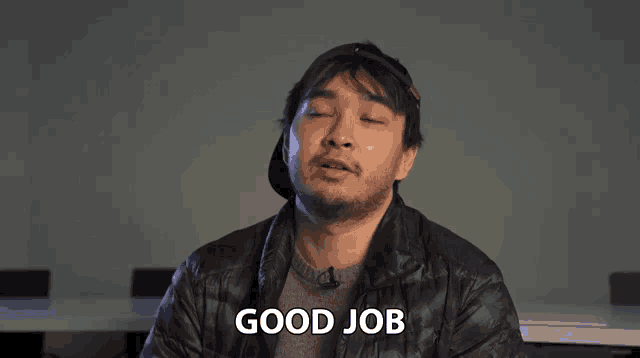 a man in a black jacket says " good job "