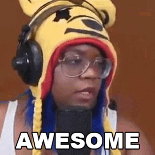 a woman wearing a bear hat and headphones is saying awesome in front of a microphone .