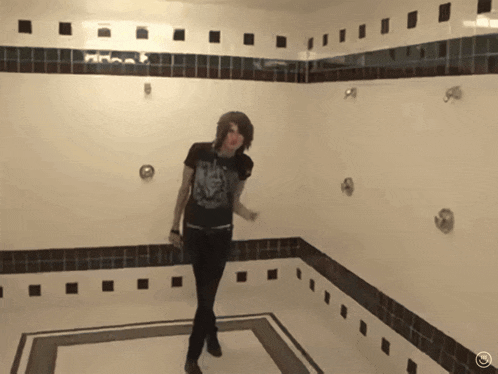 a woman in a black shirt is dancing in a shower stall