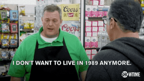 a man in a green shirt says " i don 't want to live in 1989 anymore " while talking to another man