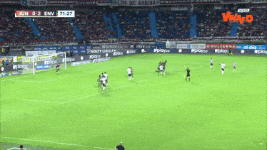 a soccer game is being played in a stadium with ads for wplay.co
