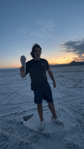 a man holding an ice cream cone in a desert
