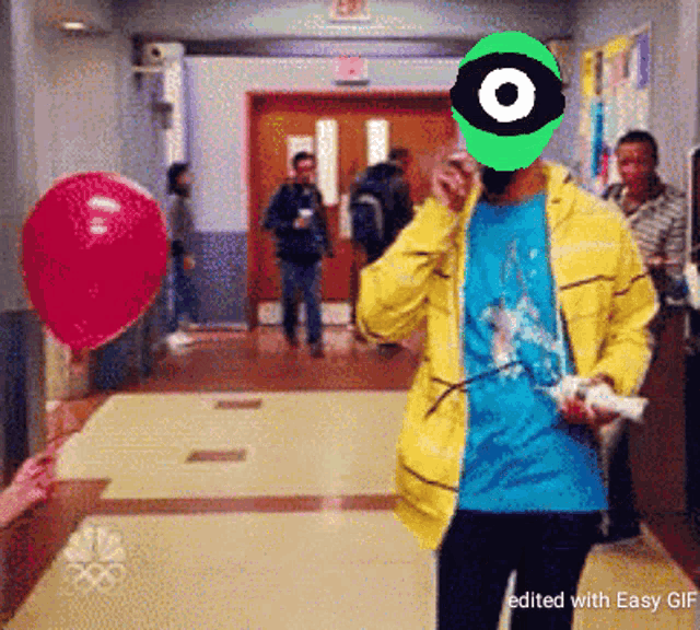 a man in a yellow jacket has a green eye on his face and a red balloon in the background