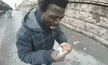 a man in a blue jacket is eating a piece of cake