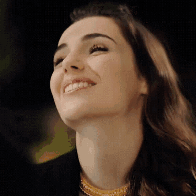 a close up of a woman 's face with a smile