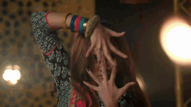 a woman with a nose ring is making a face with her hands