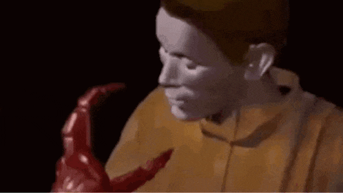 a man is holding a red monster in his arms in a cartoon .