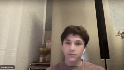 a young man wearing headphones is on a video call with the name freaky mathei