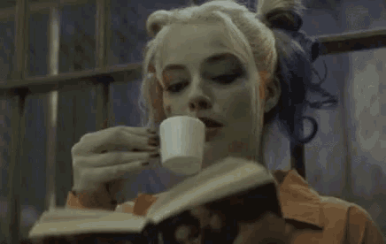 harley quinn is drinking a cup of coffee while reading a book ..