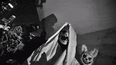 a black and white photo of a person covered in a blanket with a mask on