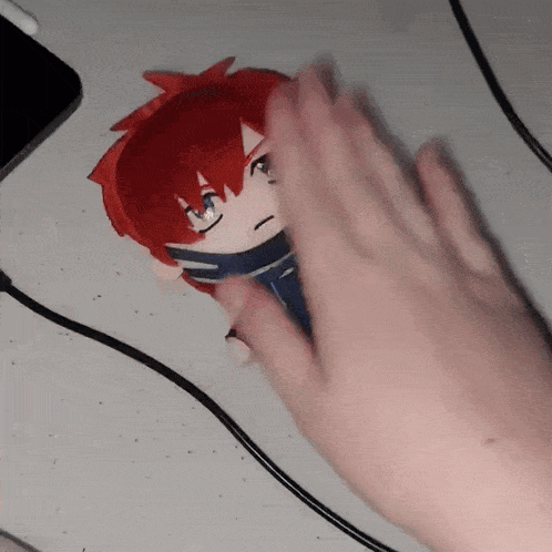 a person is holding a stuffed doll with red hair and blue eyes