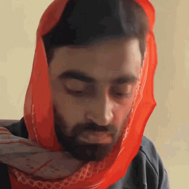 a man with a beard wearing a scarf around his head