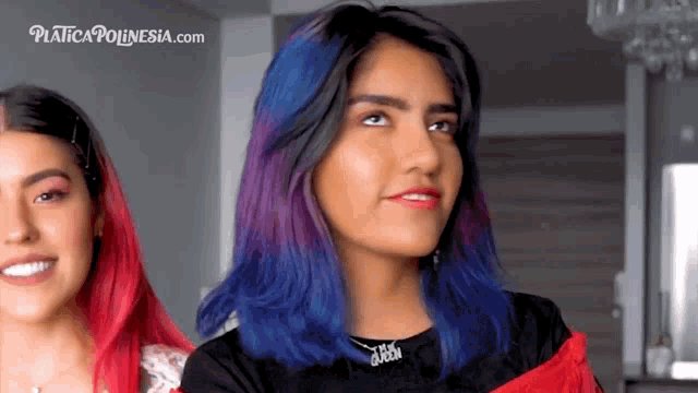 a woman with blue and purple hair is standing next to another woman