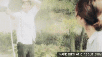 a man and a woman are standing next to each other in the woods .