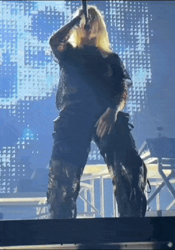 a woman is standing on a stage with a microphone in her hand .