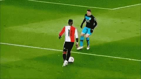 two soccer players are playing a game on a field