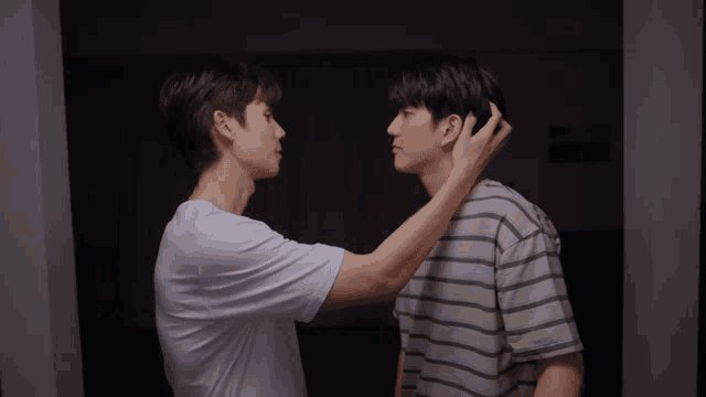 two young men are touching each other 's hair