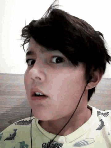 a boy wearing headphones and a shirt that says ' shark ' on it