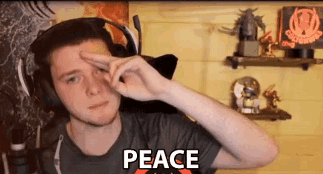 a man wearing headphones is making a peace sign with his hands .