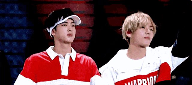 two young men are standing next to each other with one wearing a shirt that says warriors on it