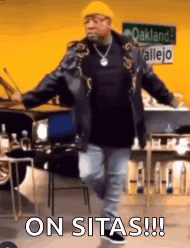a man is dancing in a room with a sign that says oakland allejo .