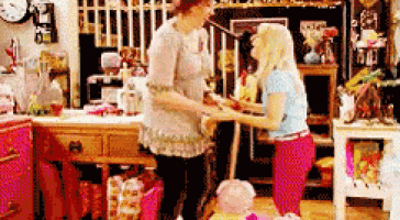 two women are standing next to each other in a room with a clock on the wall .