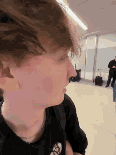 a close up of a person 's face with a man standing behind them .
