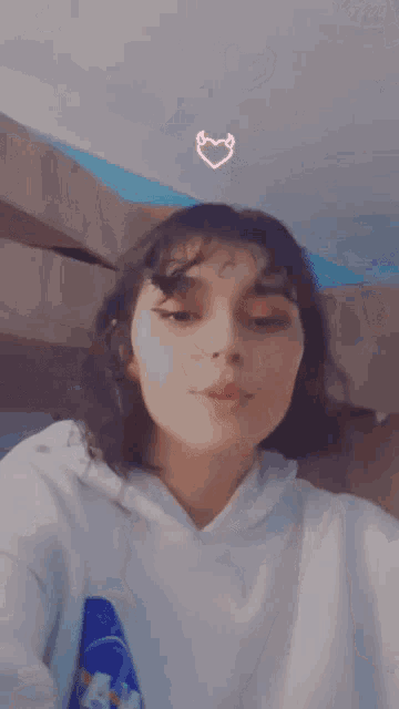 a girl with her tongue out and a heart on the ceiling