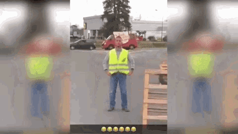 a man wearing a yellow safety vest is standing on the street .