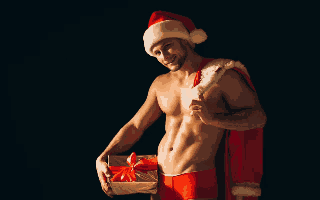 a shirtless man dressed as santa claus holding a gift