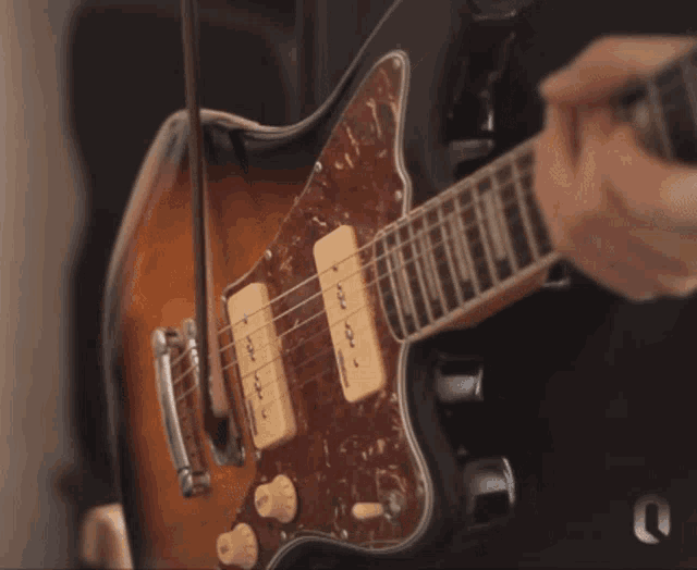 a close up of a guitar with a violin attached to the neck