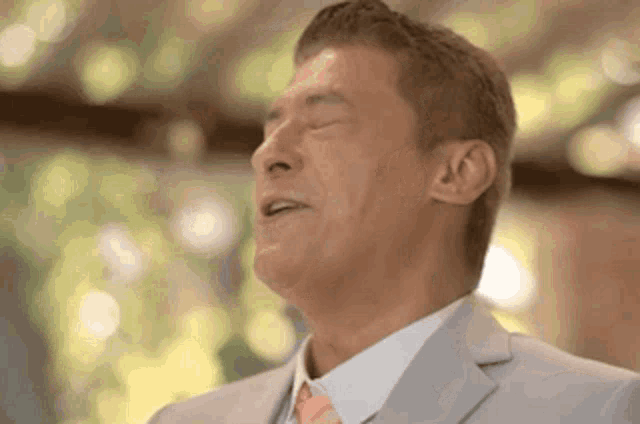 a man in a suit and tie with his eyes closed .