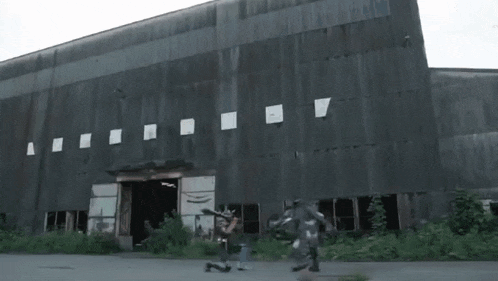 two people are walking in front of a large building .