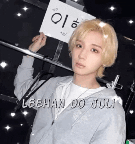 a man with blonde hair is holding a sign that says lechan do juli .