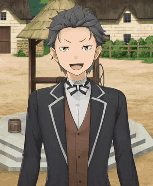 a man in a suit and bow tie stands in front of a thatched roof house