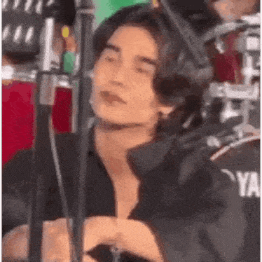 a man is sitting in front of a drum set and a microphone .