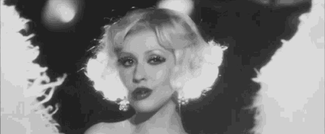 a black and white photo of a woman wearing a wig .